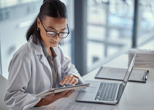 Doctor utilizing laptop and tablet