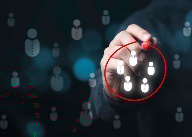 A male employee's hand circles an illustration of a group of people in red pen.