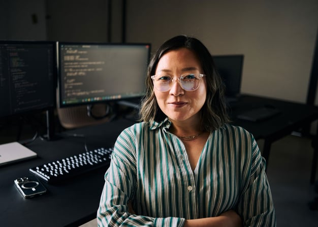 A female software engineer in front of her workstation, displaying lines of code.