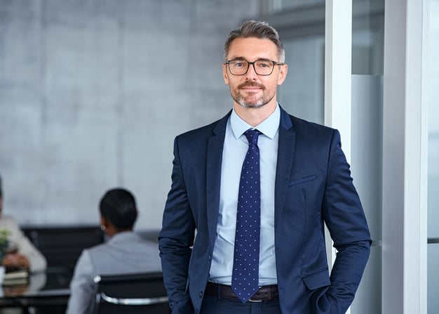 A fintech executive in a business suit inside a boardroom.