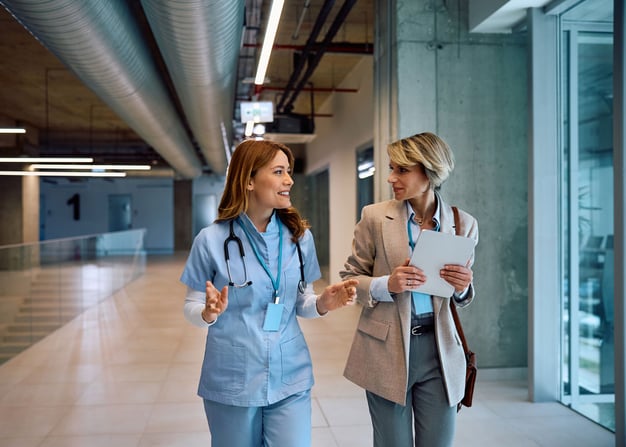 A healthcare worker and an admin walk thorugh a regional health center