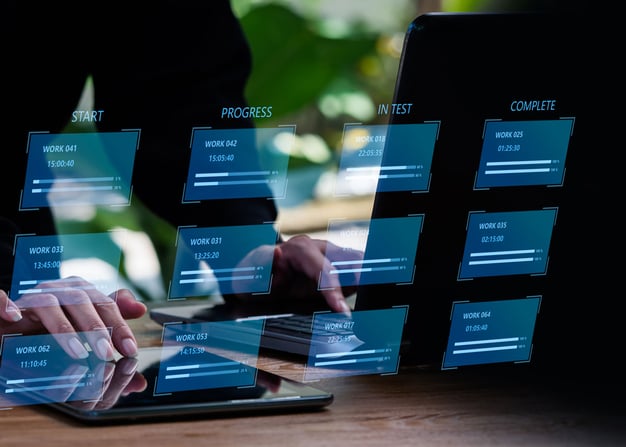 An employee monitors the progress of a software project on their laptop.