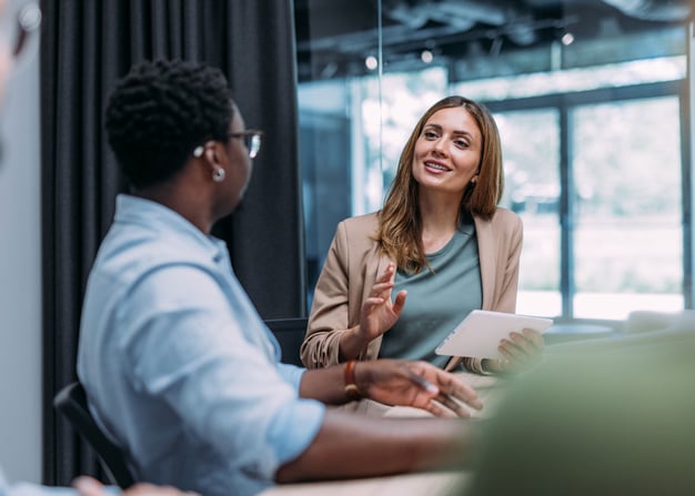 Two female executives meet to collaborate on a project.