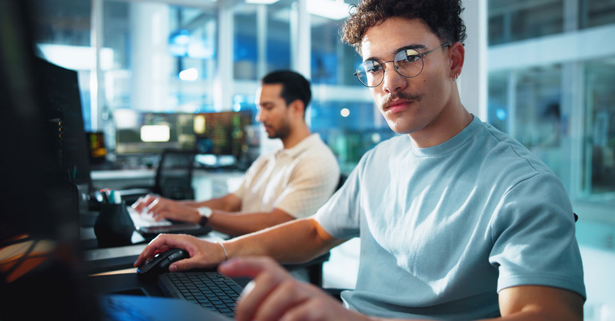 Two male software engineers work side by side.