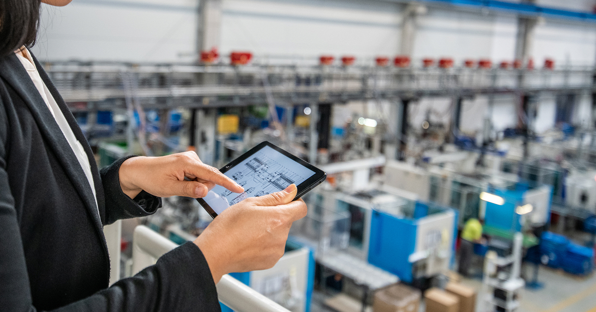 factory-manager-viewing-blueprint-on-tablet-above-manufacturing-floor